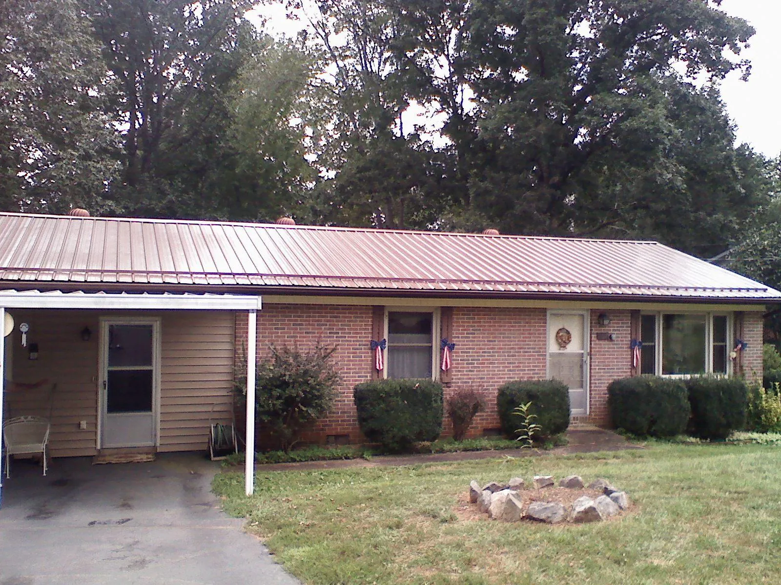 Bronze metal roof and carport on a brick ranch home — Roof Repair work by our crew in Greenbush